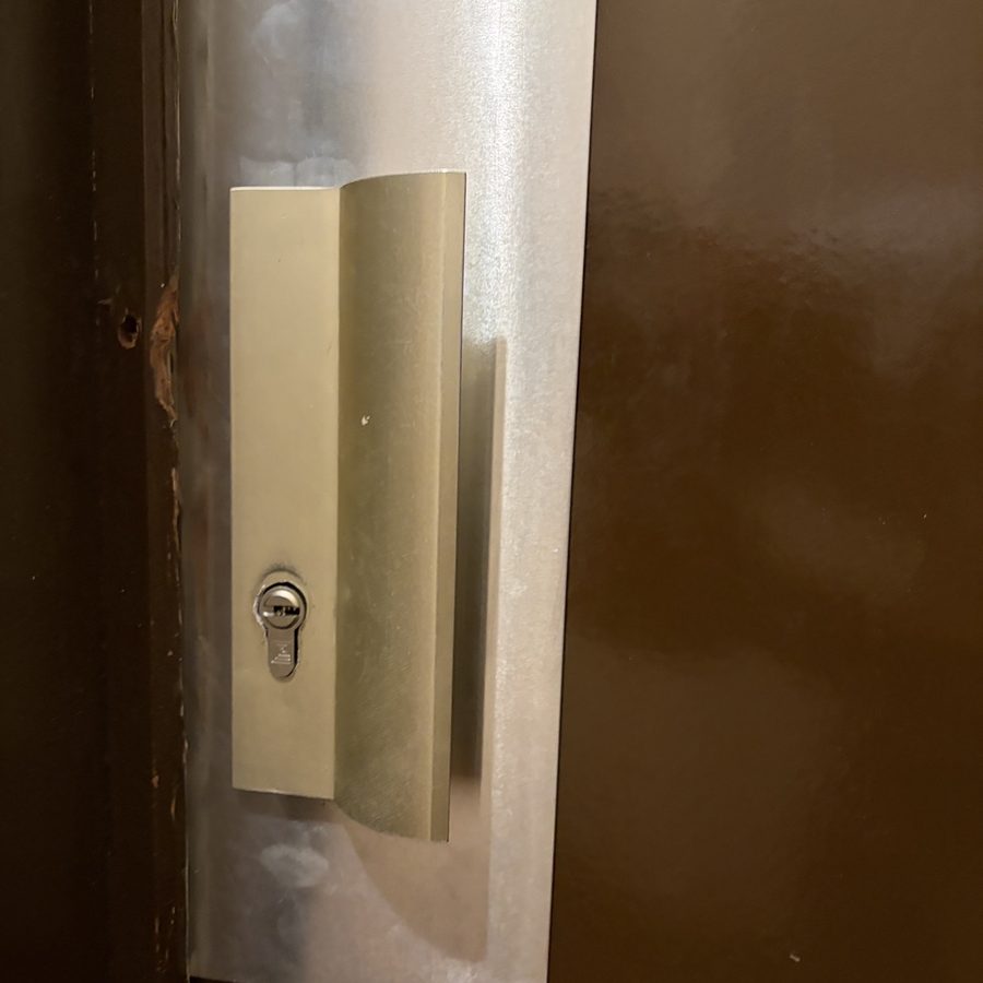 Plaque de protection inox et cylindre de sécurité posés sur porte d'entrée — SDE38