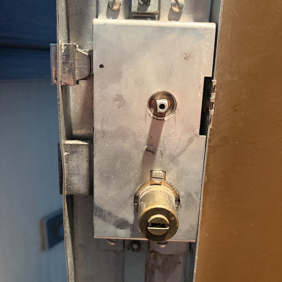 Serrure en applique et cylindre laiton sur porte métallique — intervention SDE38
